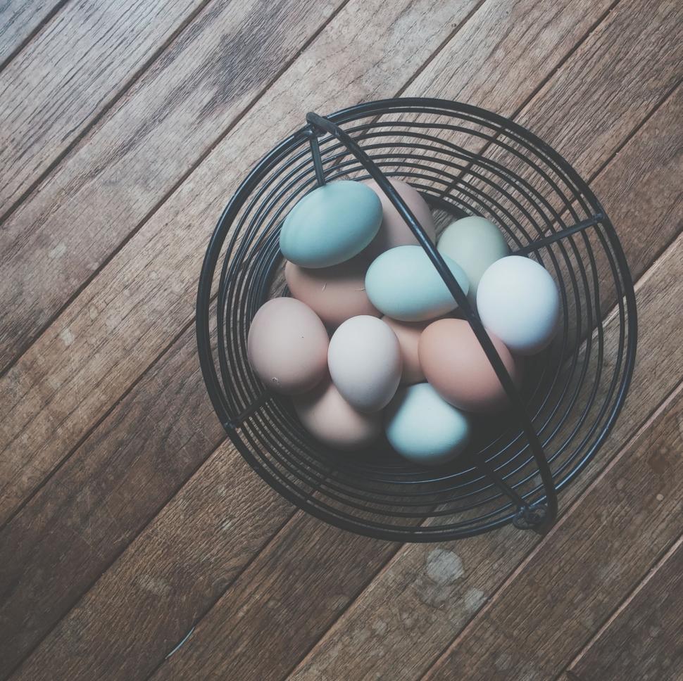 Free Image of A basket of eggs on a wood surface 