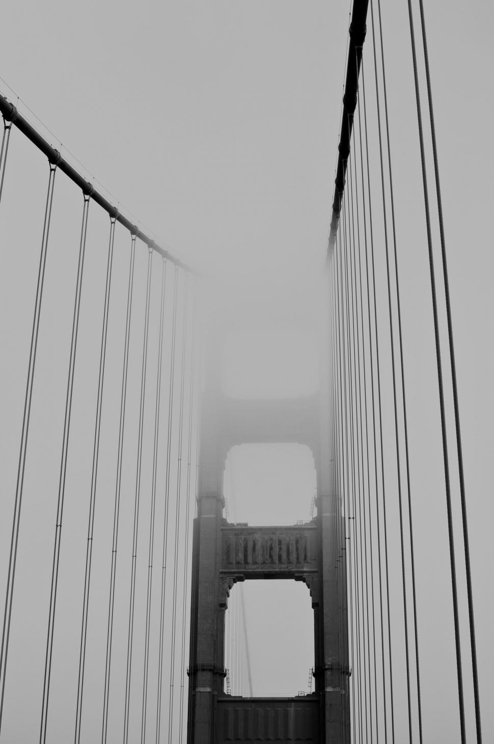 Free Image of A bridge with cables and a foggy sky 