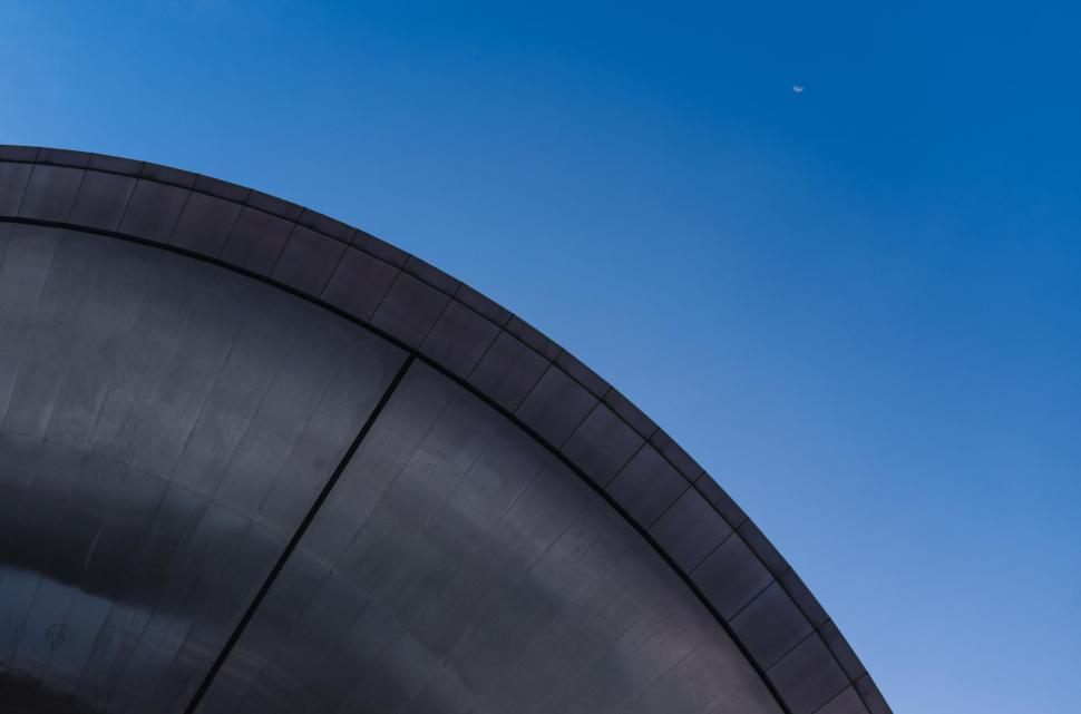 Free Image of A black circular object with a blue sky 