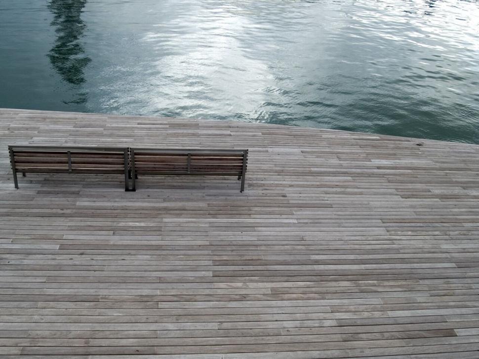 Free Image of Wooden jetty with empty benches by the water 