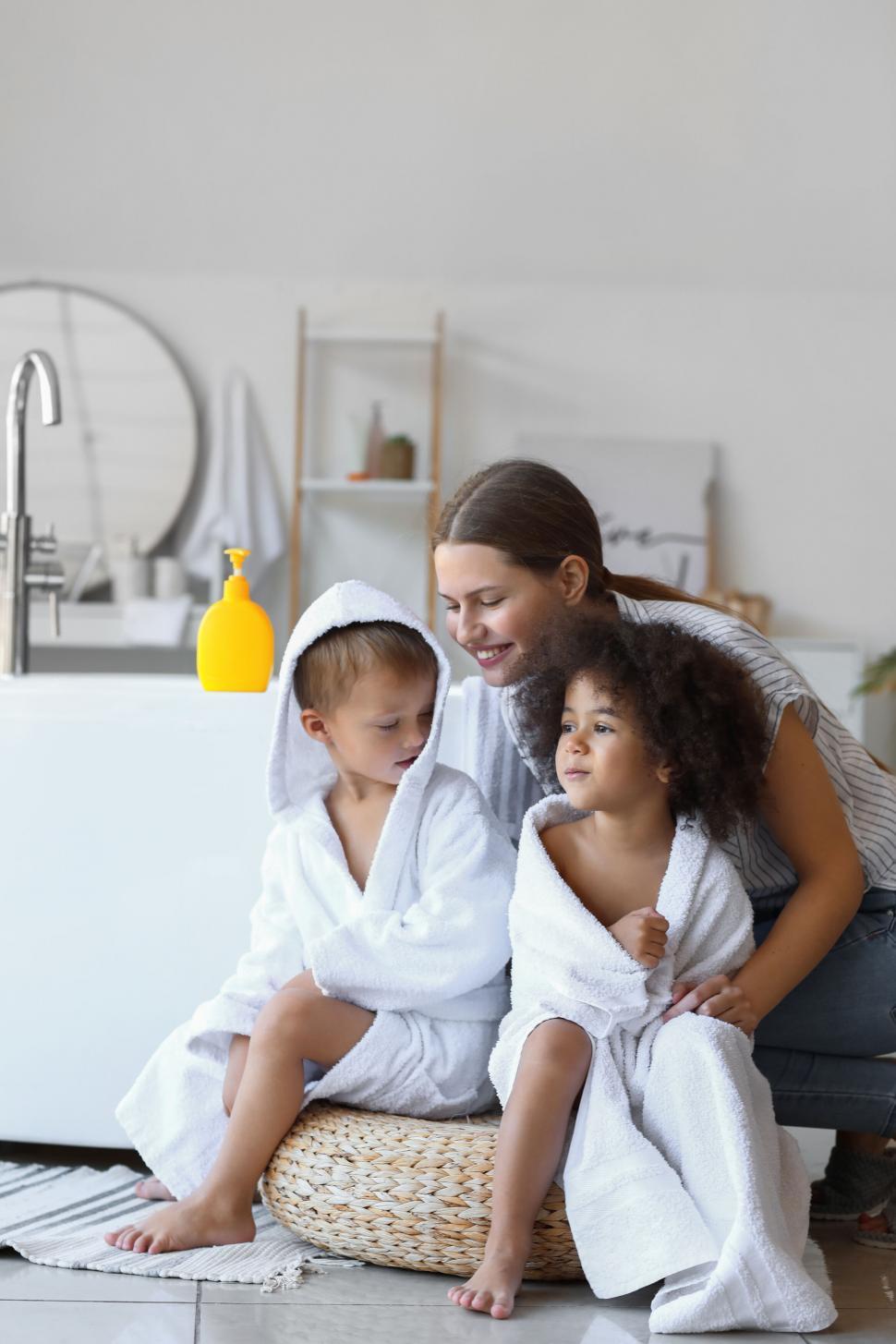 Free Image of Mother with children in bathrobes smiling 