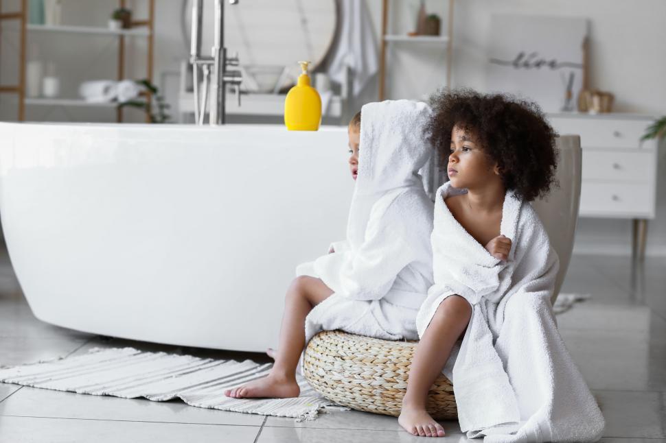 Free Image of Two children in bathrobes by a bathtub 