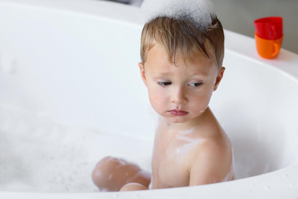 Free Image of Toddler with foam on head in bathtub 