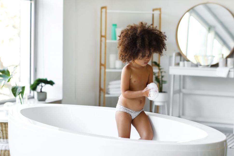 Free Image of Young child with curly hair in a bathtub 