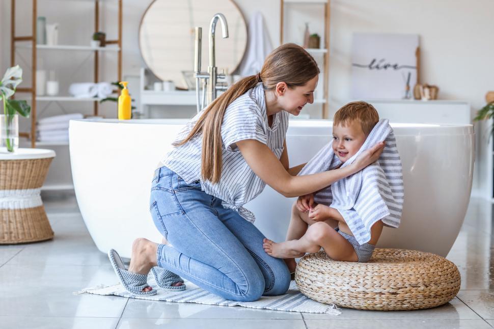 Free Image of Mother drying off son with a towel after bath 
