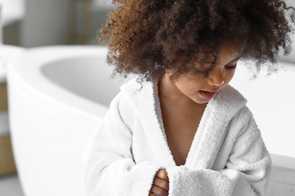 Free Image of Child in bathrobe after bath looking down 