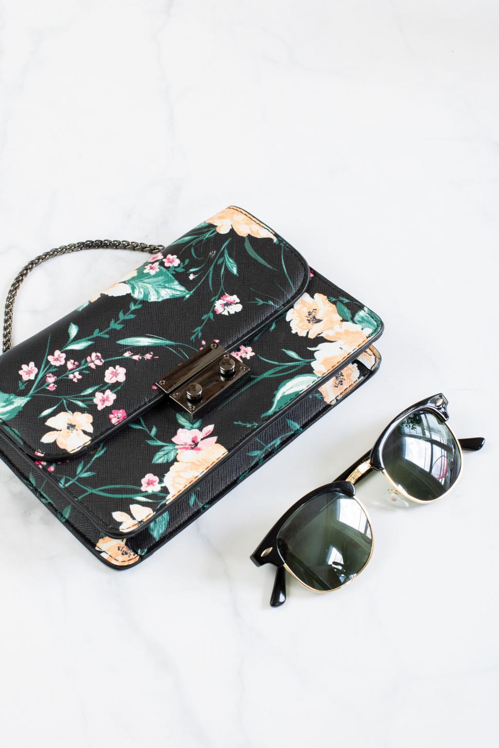Free Image of Floral purse and sunglasses on marble 
