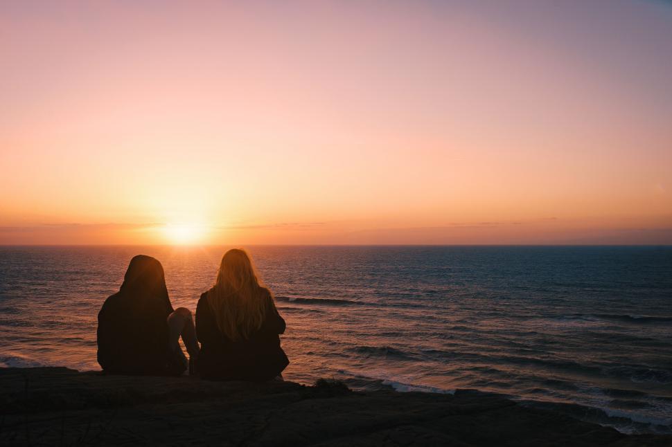 Free Image of Two people watching a sunset at sea 