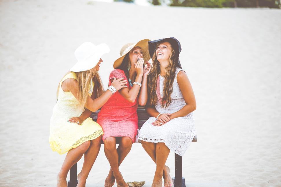 Free Image of Three women laughing together on the beach 