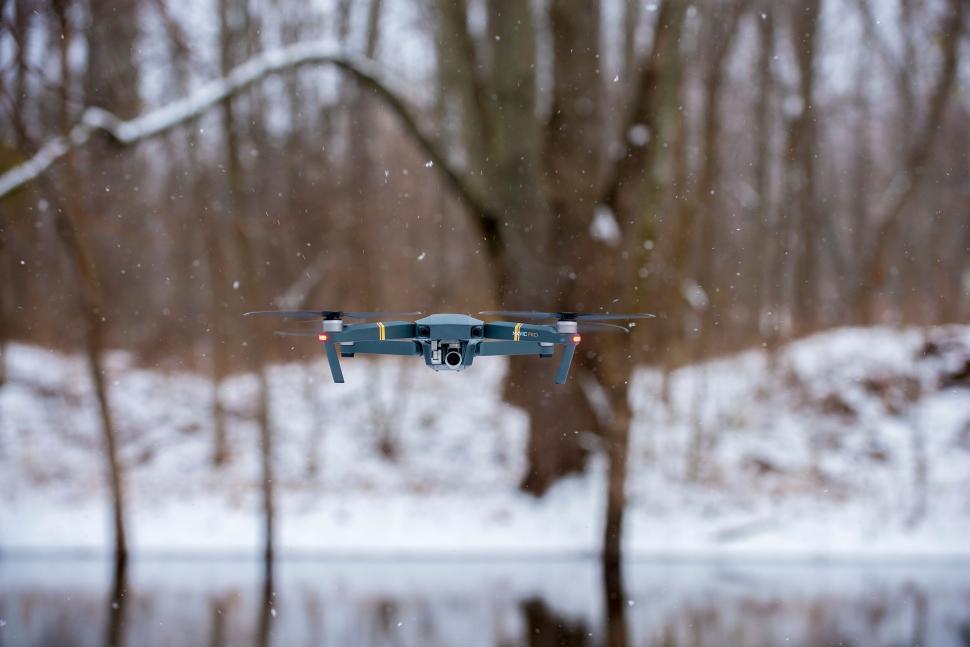 Free Image of Flying drone captured mid-air in snowy backdrop 
