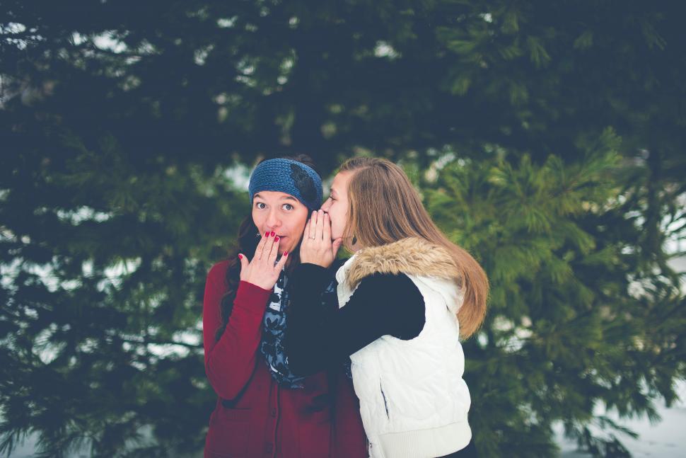 Free Image of Two women sharing a secret in snow 