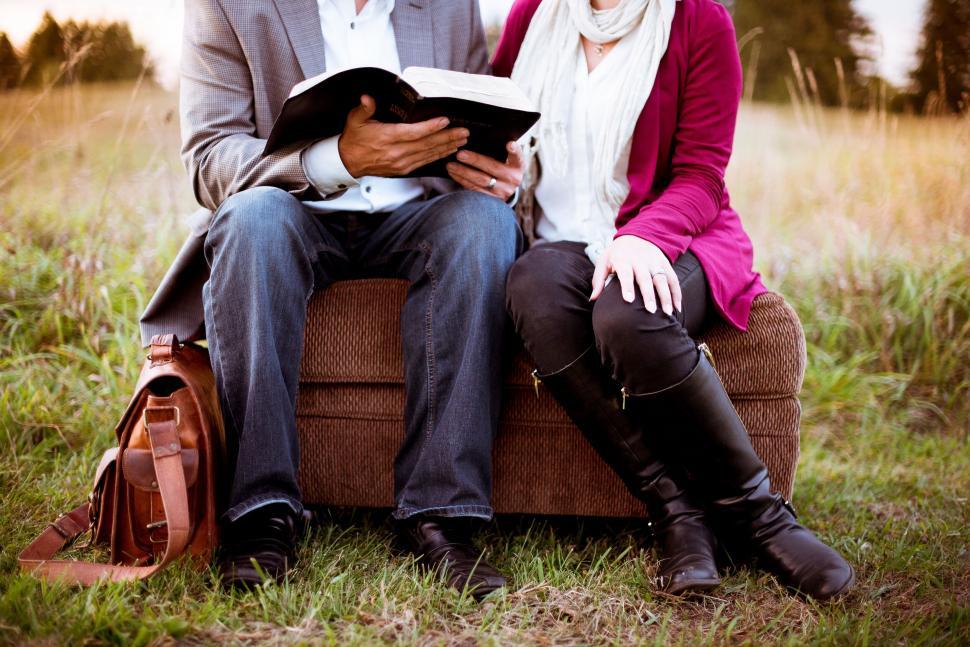 Free Image of Couple reading a book together outdoors 