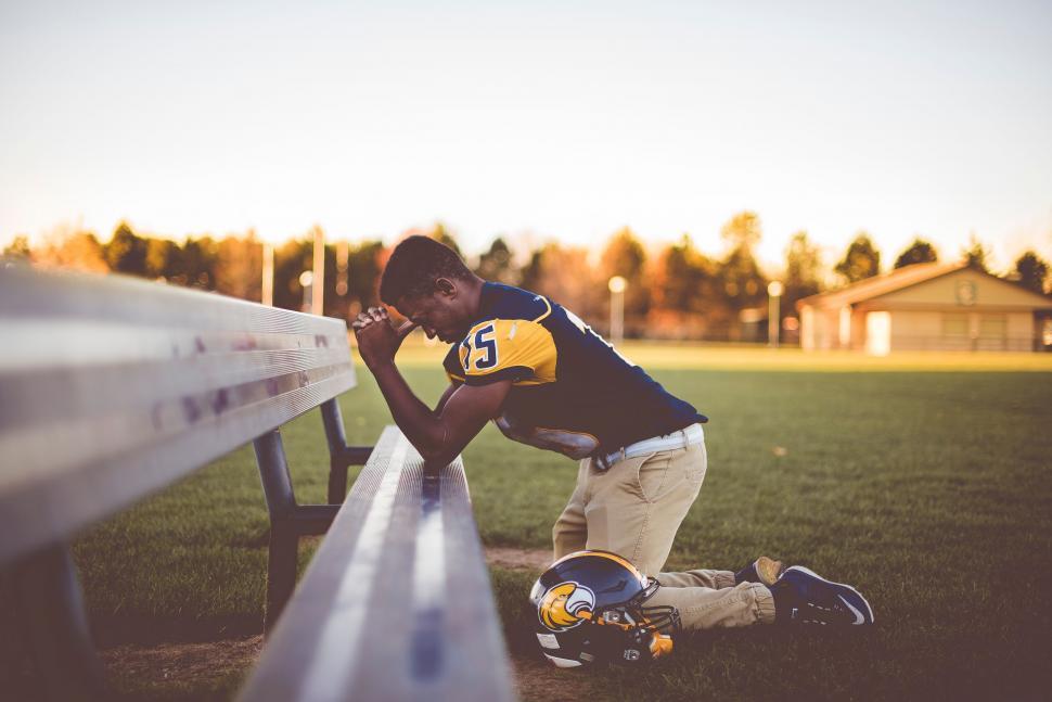 Free Image of Football player kneeling on field 