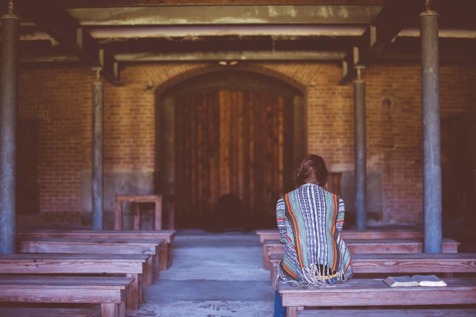 Free Image of Person sitting in church pew viewed from behind 
