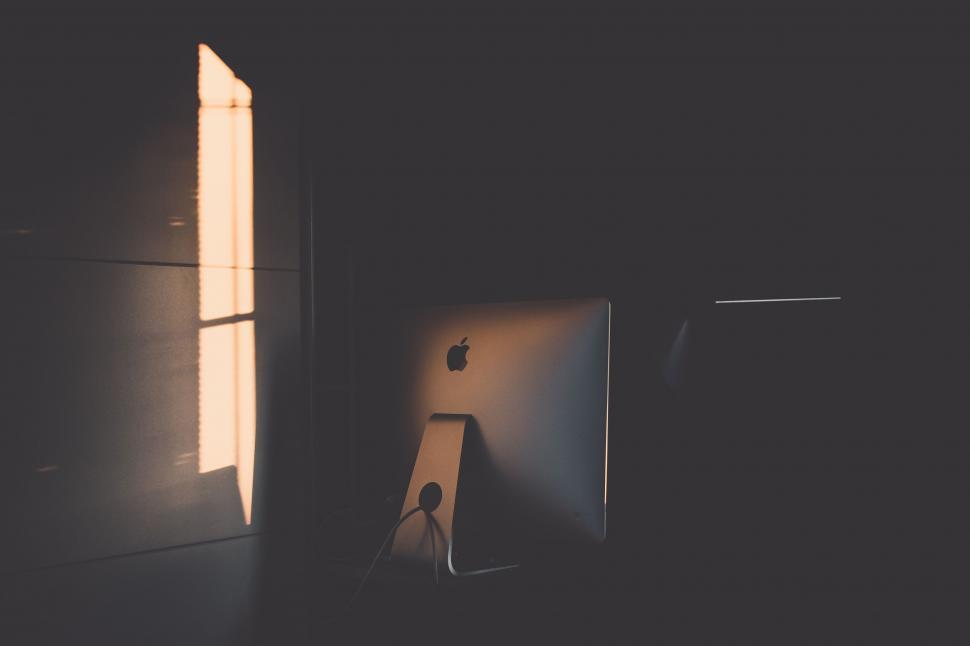 Free Image of Silhouette of iMac on desk in dark room 