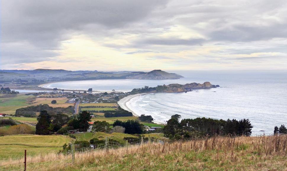 Free Image of Coastal view of rolling hills and calm sea 