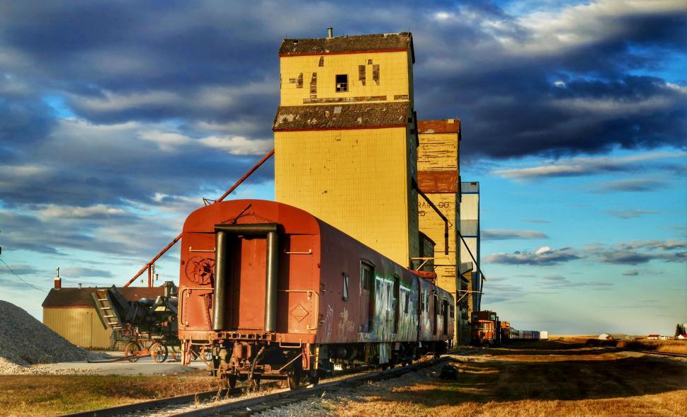 Free Image of Vintage train by historical grain elevator 