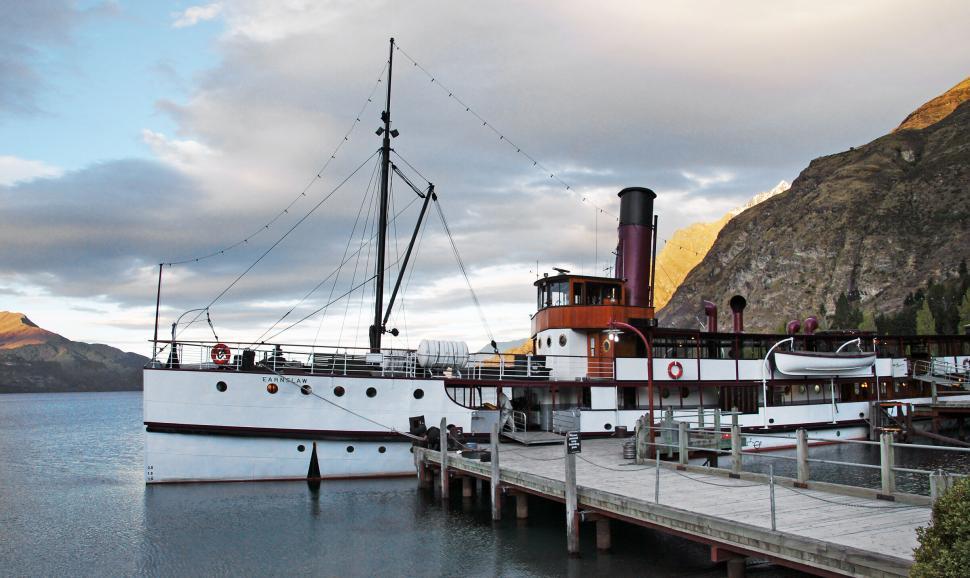 Free Image of Historic steamship docked at mountain lake pier 