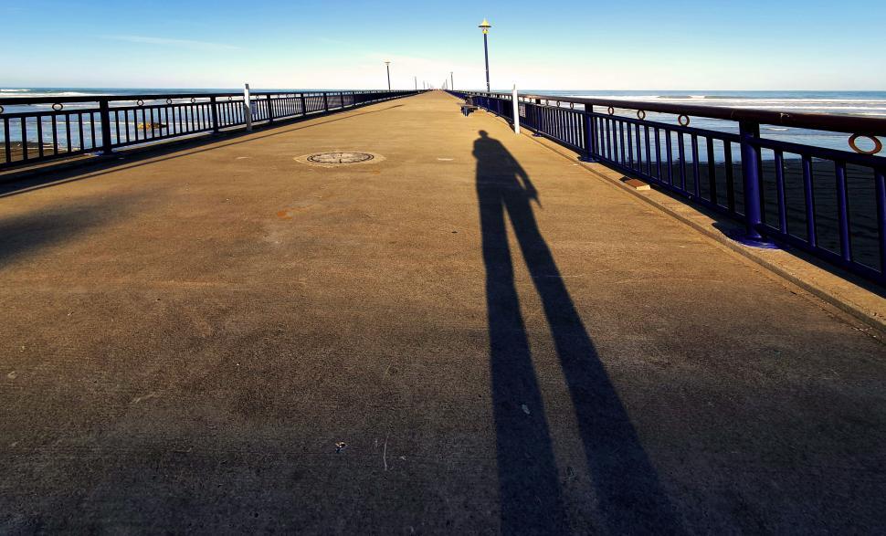 Free Image of Pier with shadow casting long on ground 