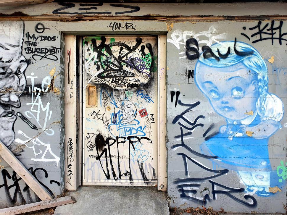 Free Image of Graffiti-covered door and wall with urban art 