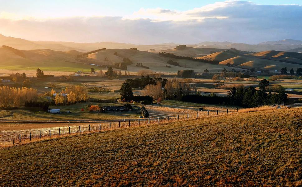 Free Image of Golden sunset over rolling hills and farmland 