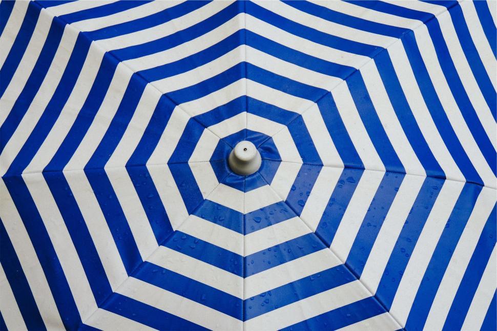Free Image of Blue and white striped beach umbrella 
