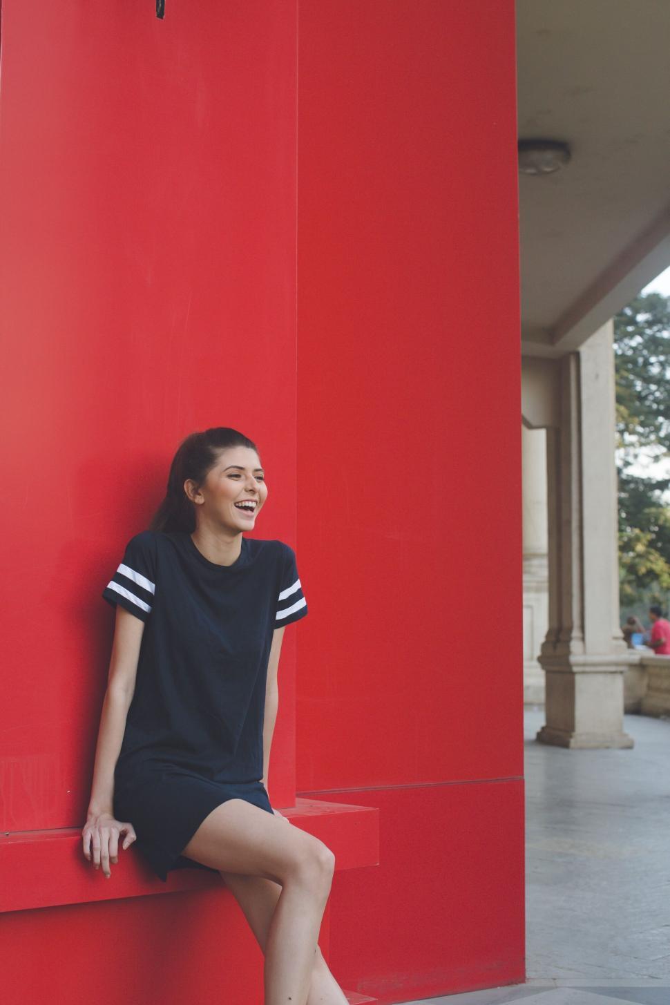 Free Image of Woman sitting and laughing in red alcove 