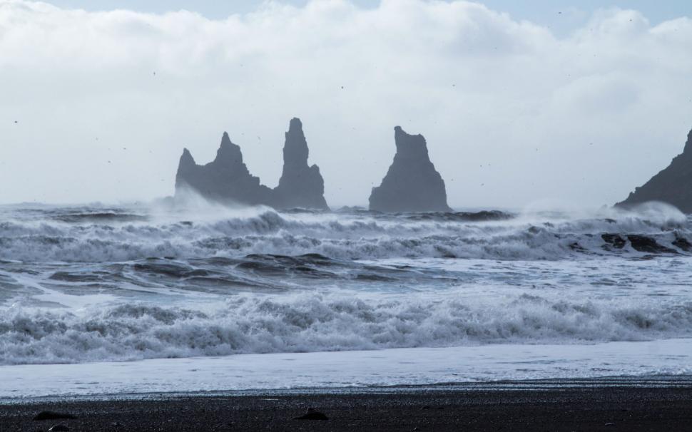 Free Image of Dark waves crashing on rocky beach formations 