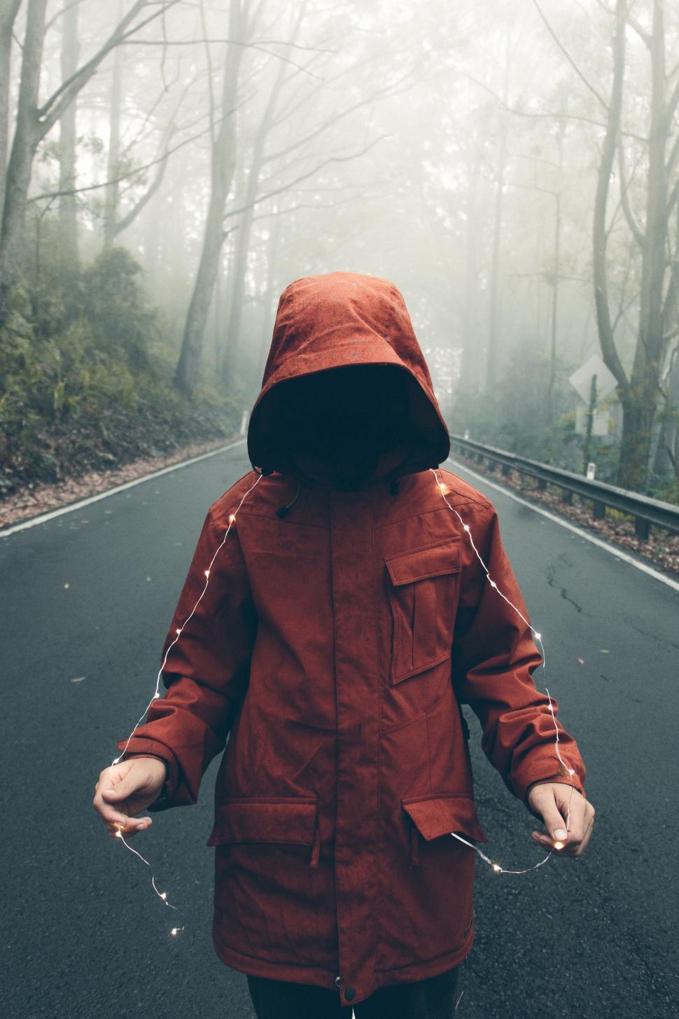 Free Image of Person in red hooded coat on foggy road 