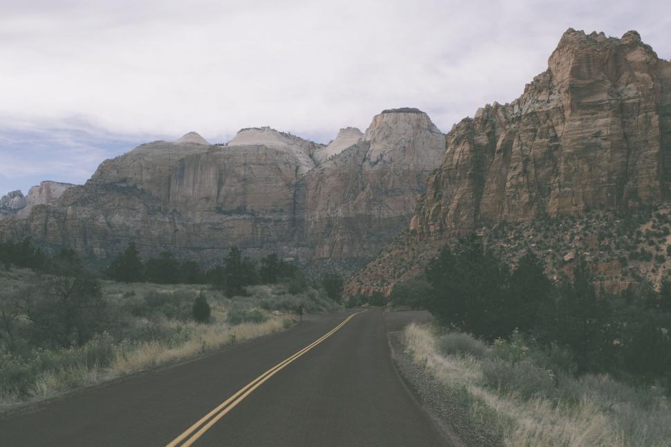 Free Image of Desolate road leading to towering rock formations 