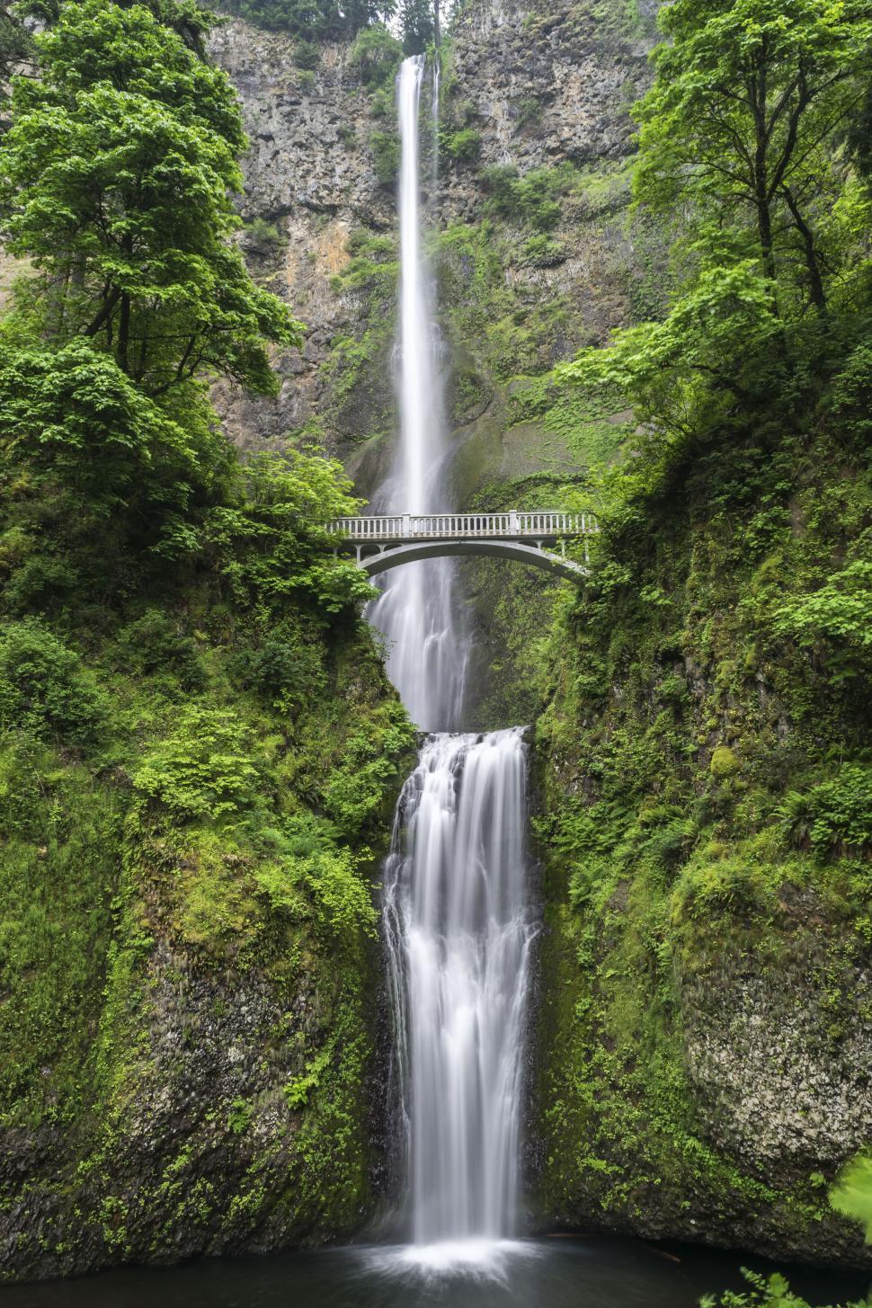 Free Image of Majestic waterfall with a bridge across it 