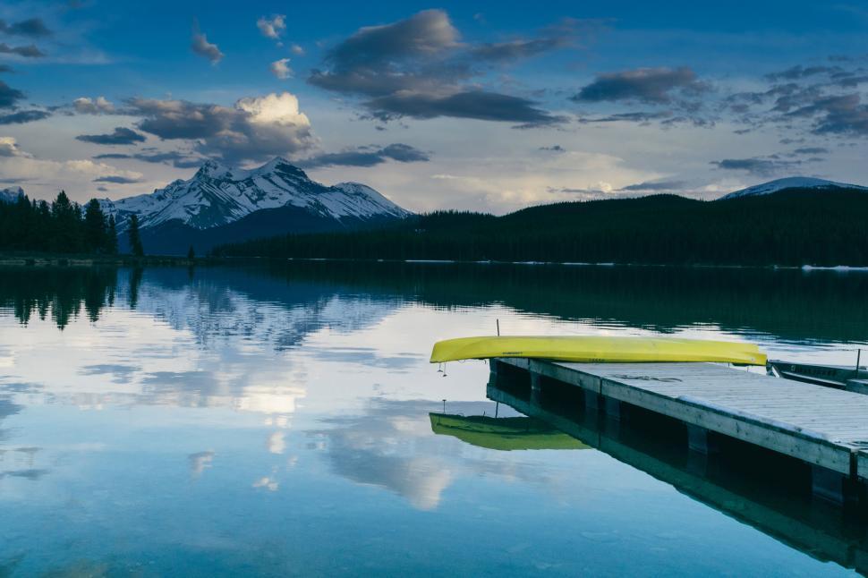 Free Image of Serene mountain lake with a docked canoe 