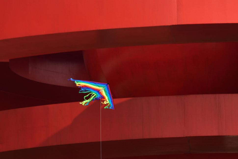 Free Image of Colorful kite flying against red backdrop 