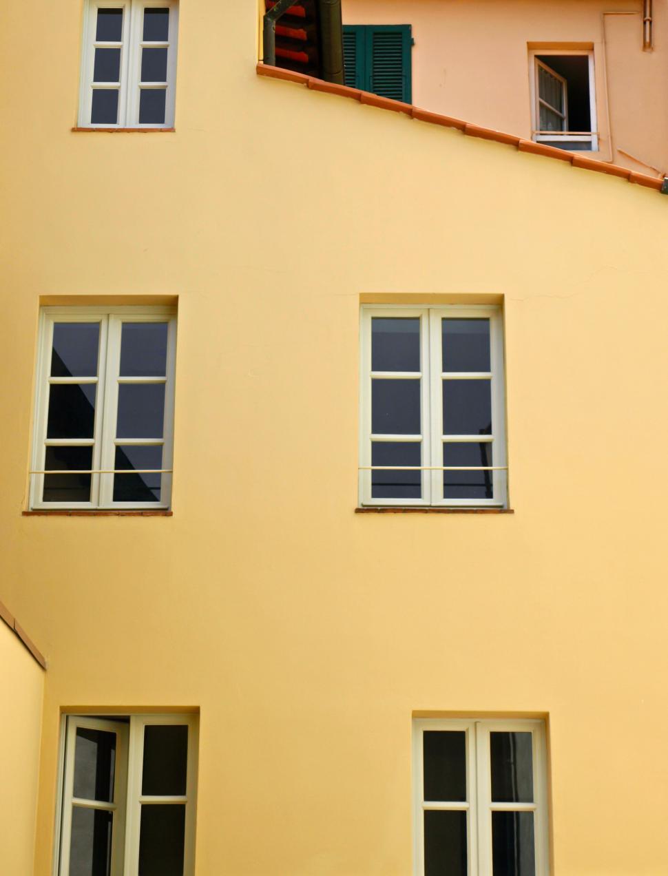 Free Image of Bright yellow building with green shutters 