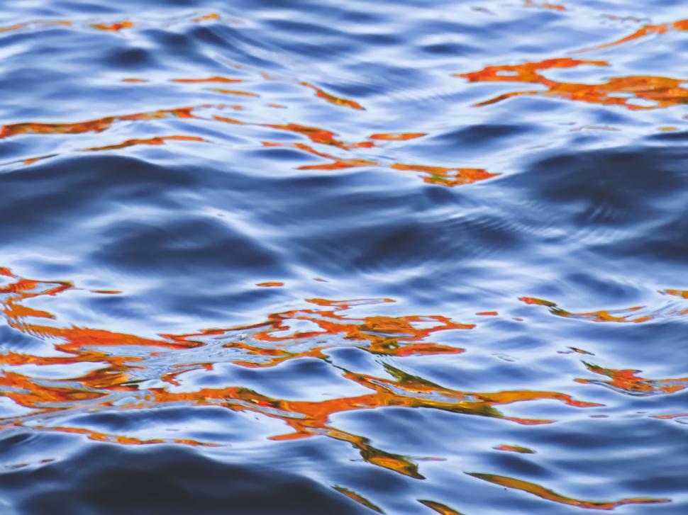 Free Image of Vivid orange reflection on rippling water 