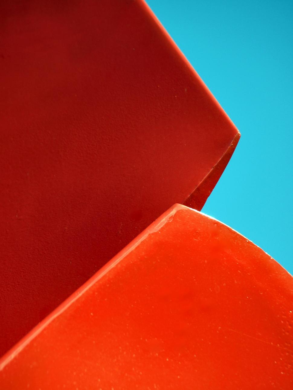 Free Image of Abstract red geometric shapes against blue sky 