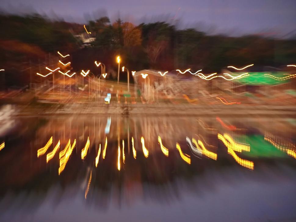 Free Image of Blurred city lights reflecting on water 