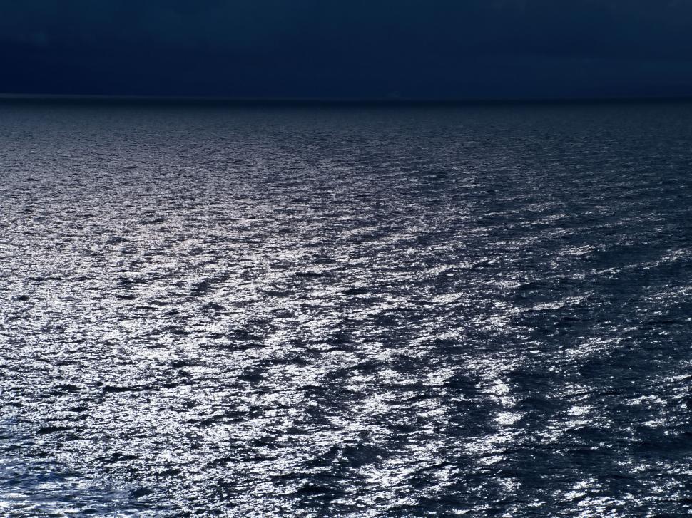 Free Image of Dark moody seascape with sunlight reflection 