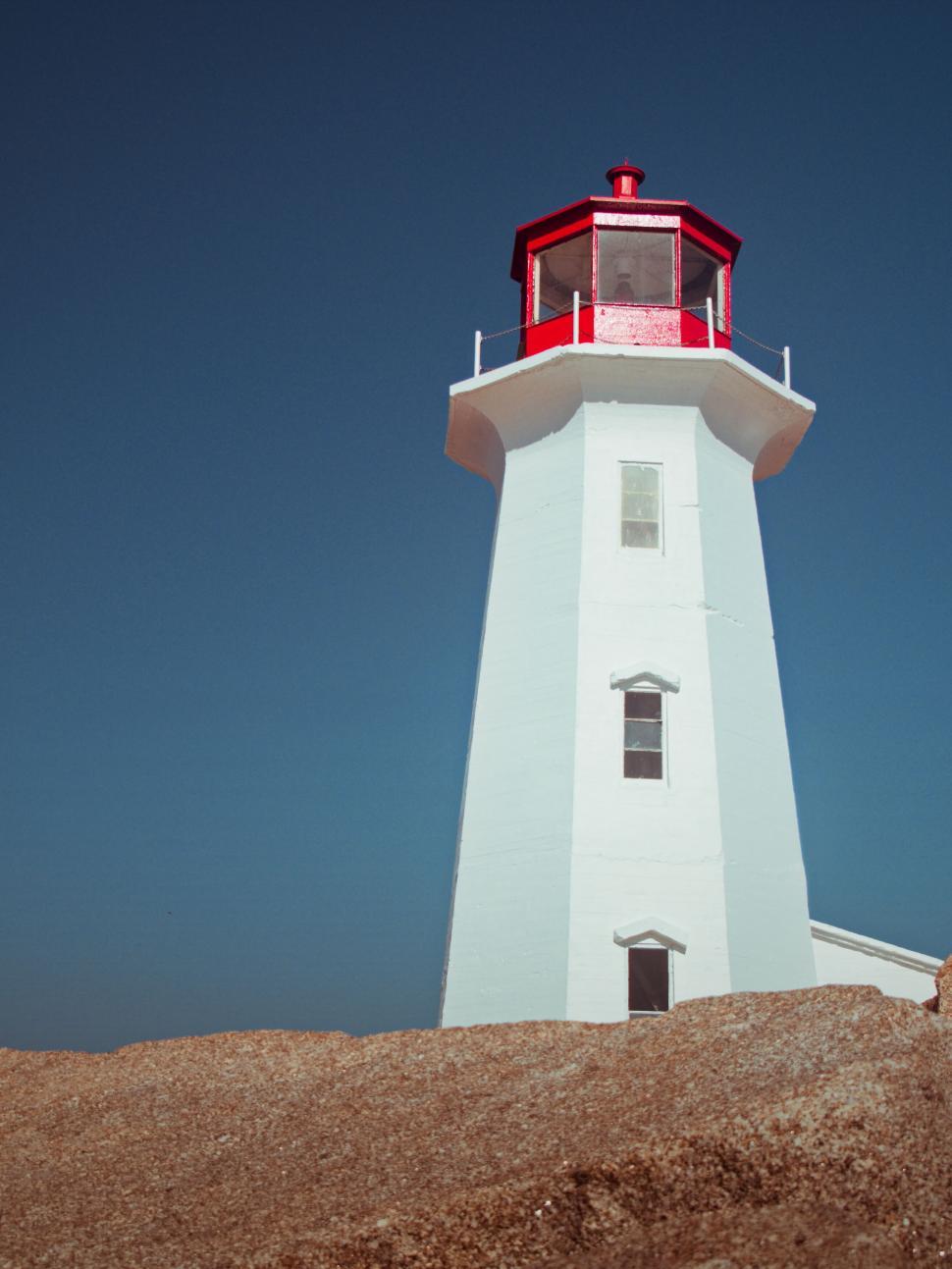 Free Image of Red-topped lighthouse standing by the sea 