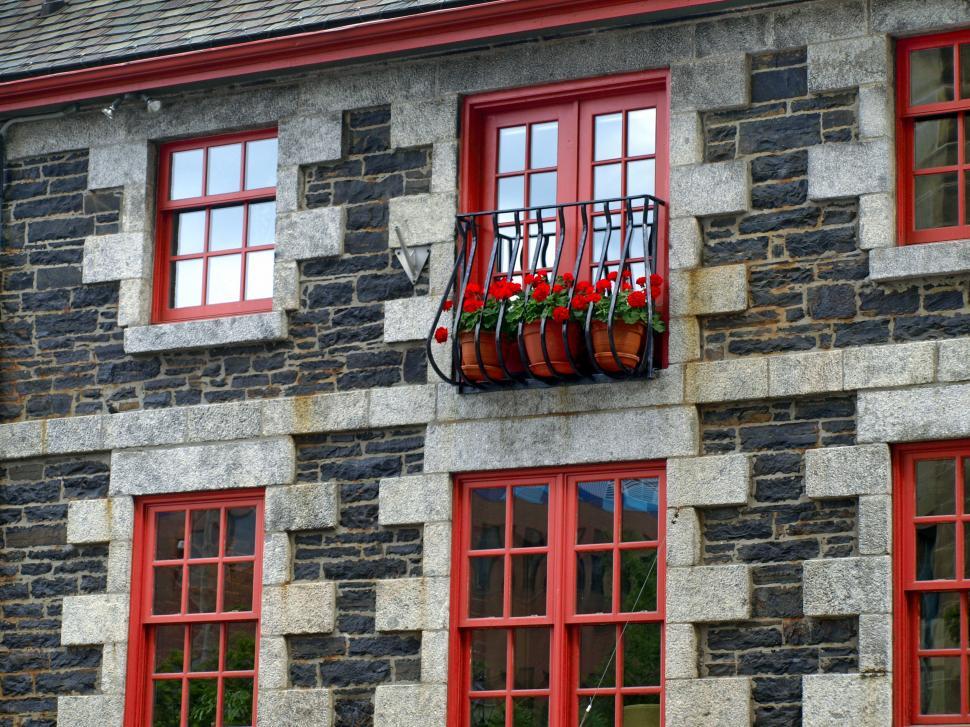 Free Image of Stone house with red windows and flower balcony 