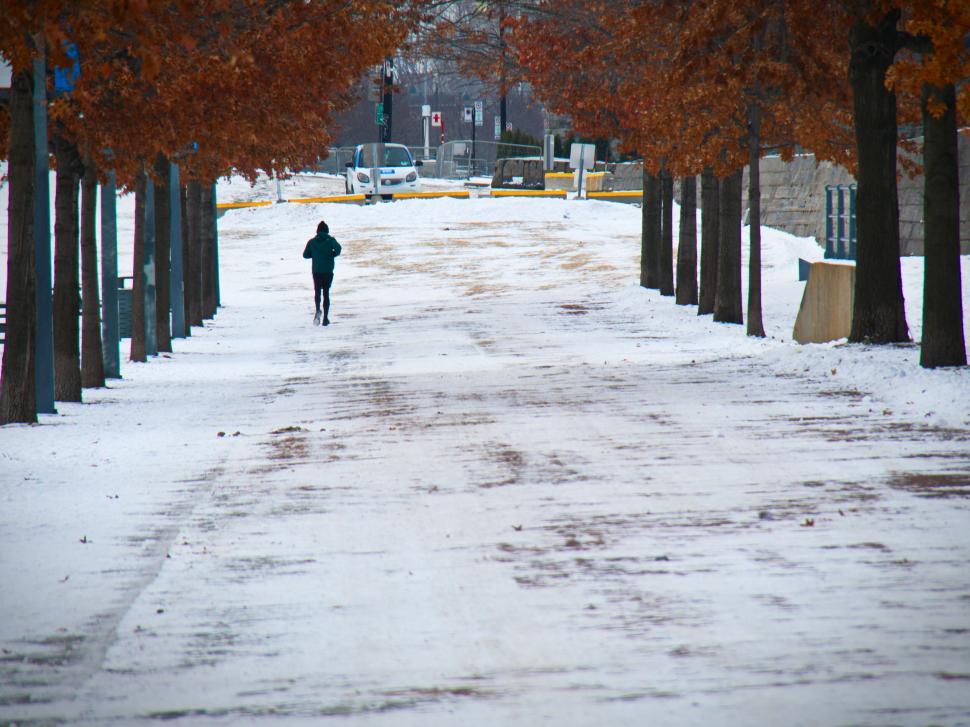 Free Image of Lonely figure walking down snowy path 