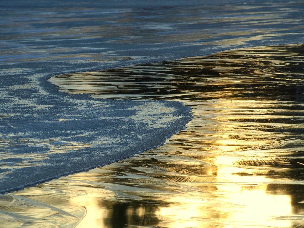 Free Image of Frozen lake surface with golden sunlight 