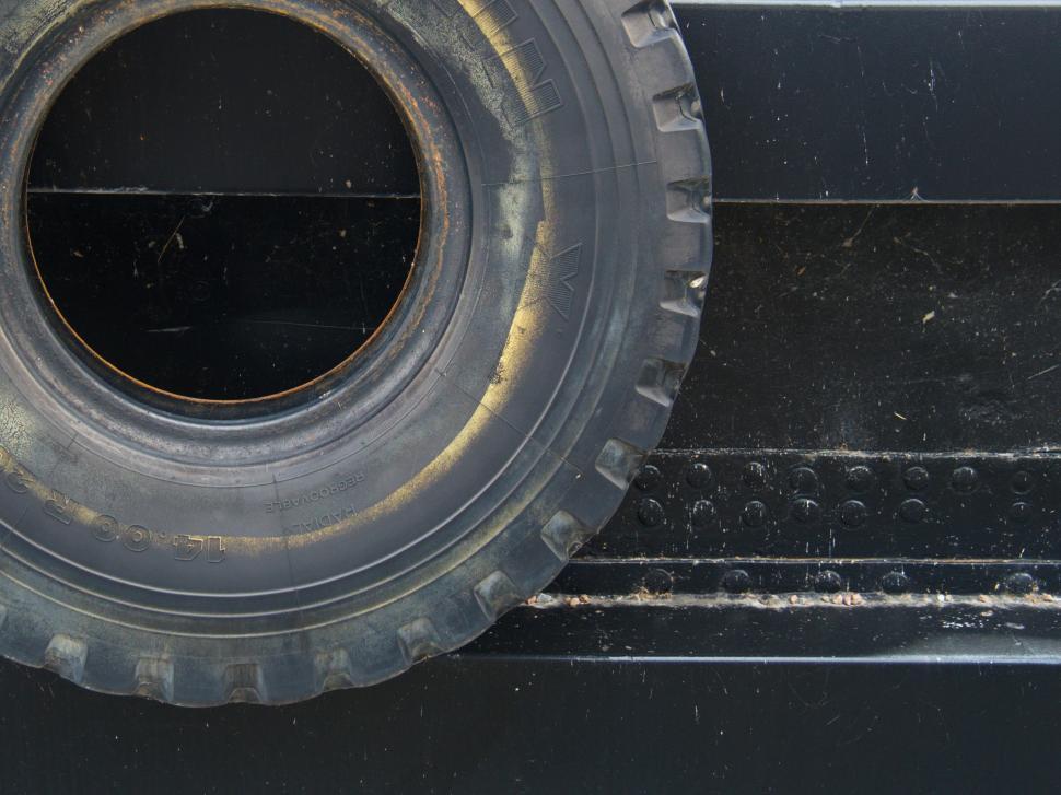 Free Image of Close-up of black tire against metal texture 
