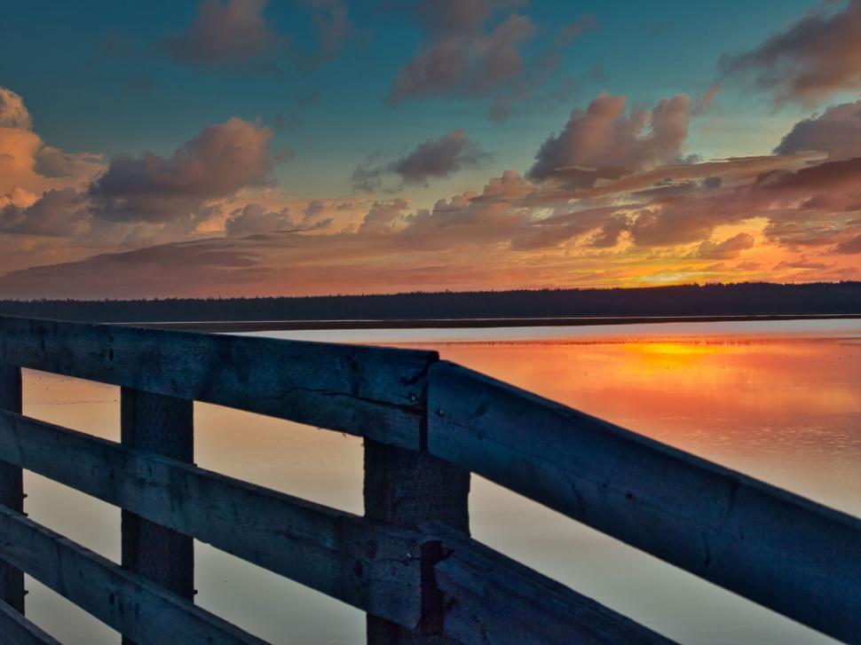 Free Image of Sunset viewed from a wooden bridge lakeside 
