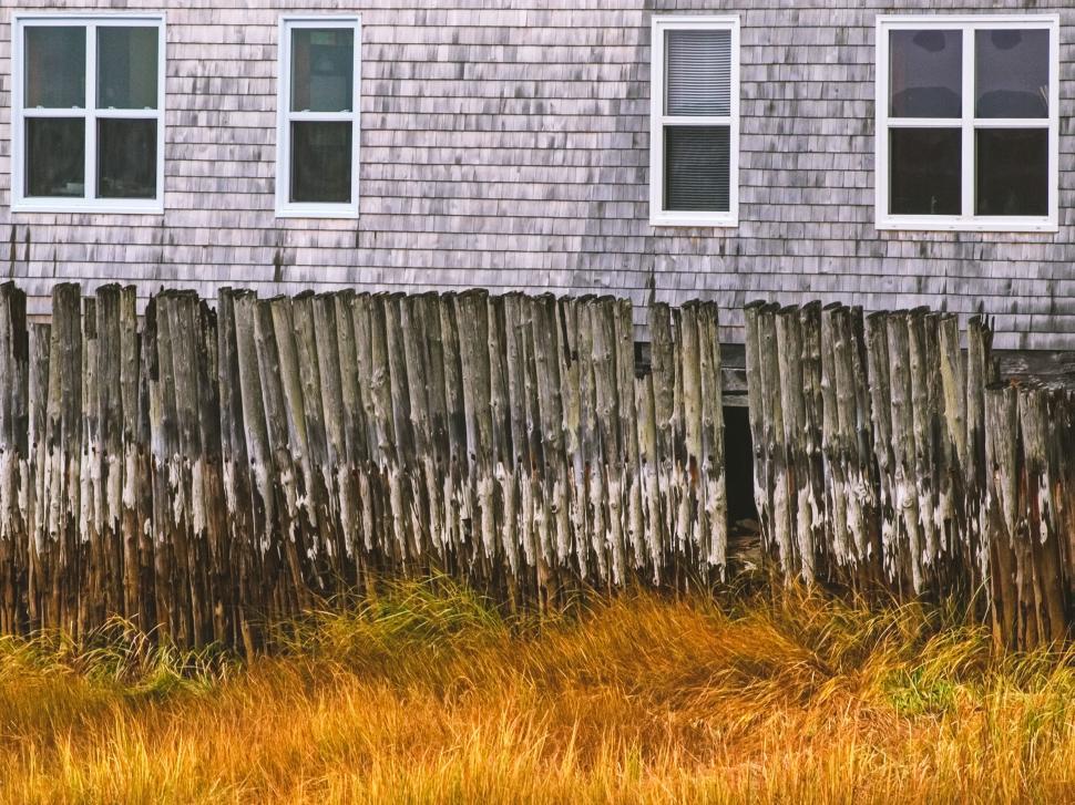 Free Image of Weathered wooden fence by a traditional house 