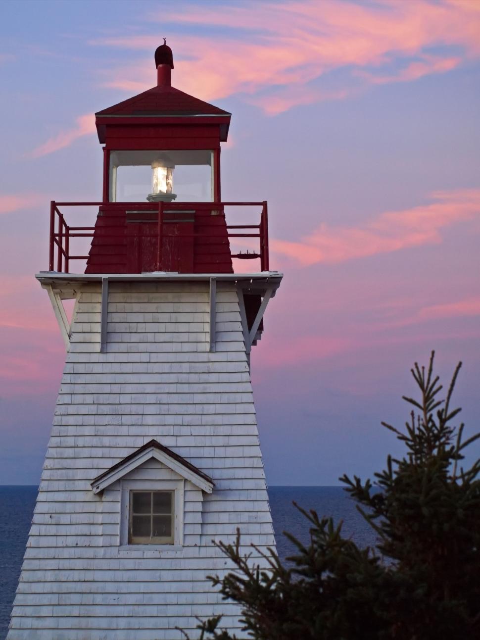 Free Image of Red and white lighthouse at twilight 