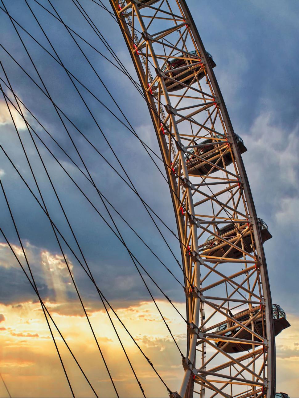 Free Image of Sunset sky behind a ferris wheel structure 