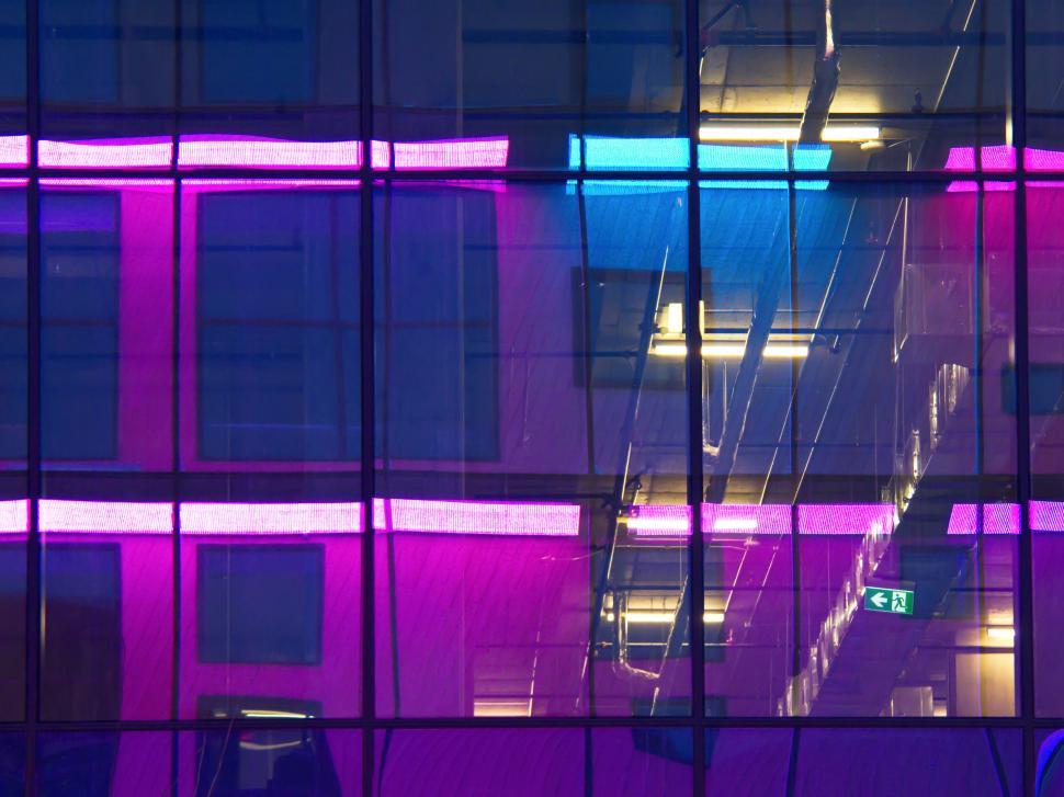 Free Image of Neon Lights Reflected in Glass Building at Night 