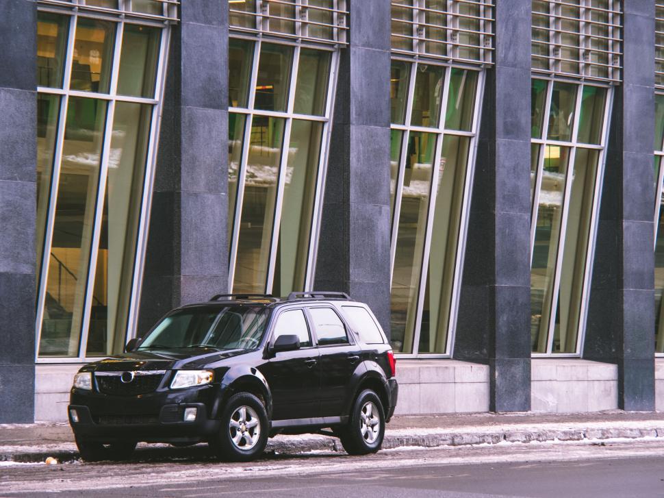 Free Image of Black SUV parked by modern building 