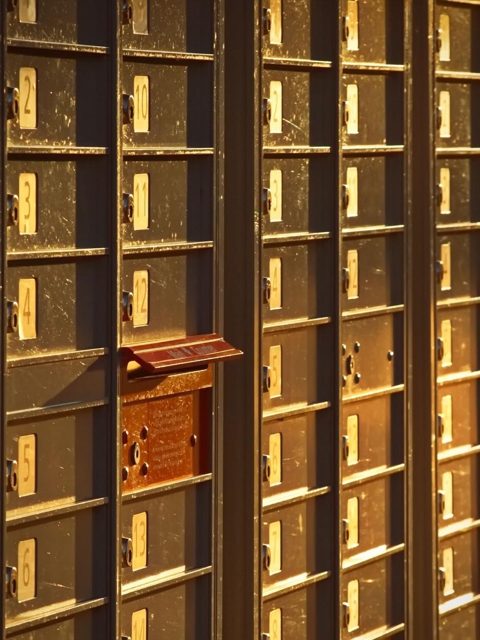 Free Image of Mailboxes with an open one catching light 